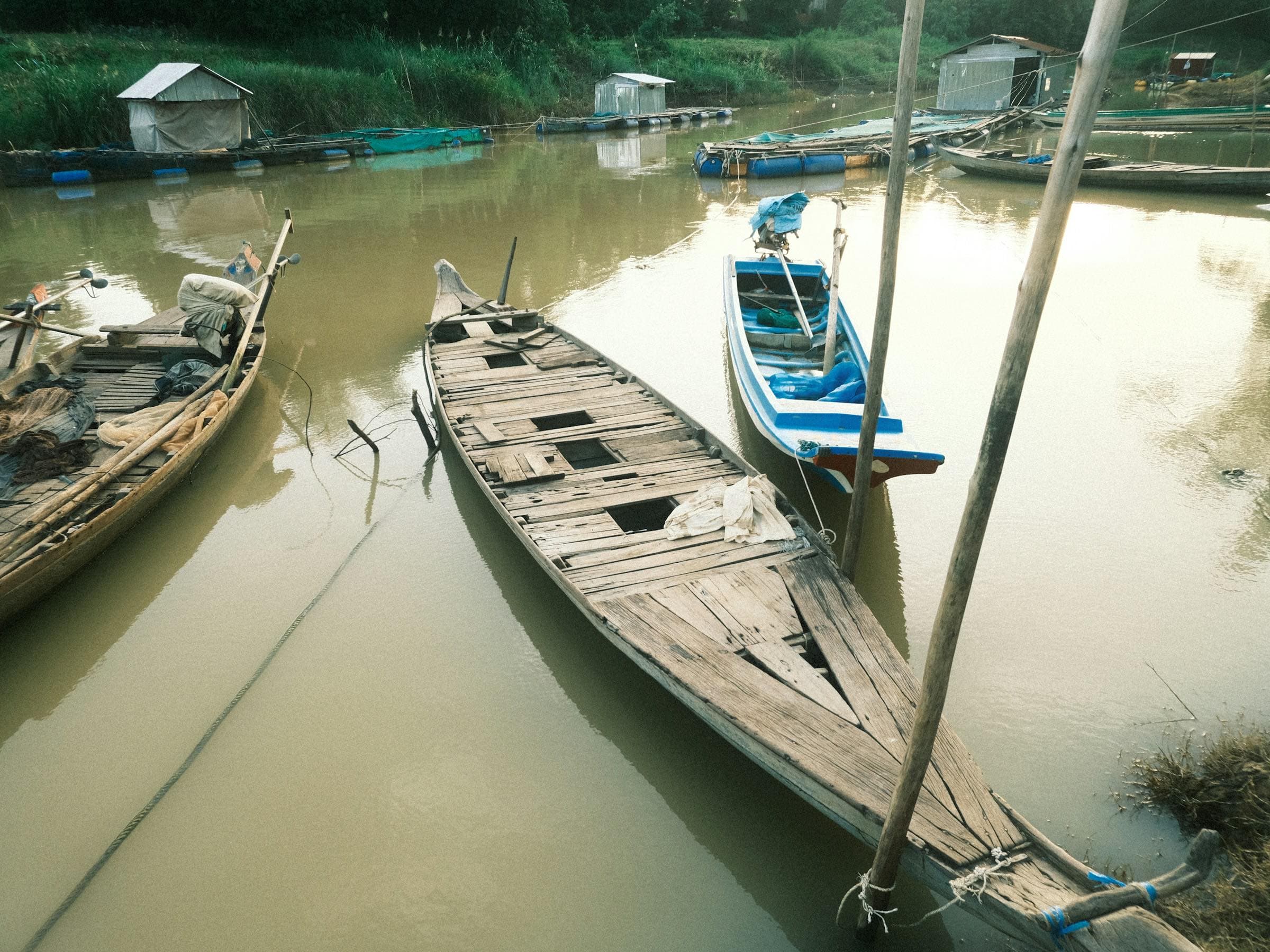 Long wooden river boats on still water in Battambang