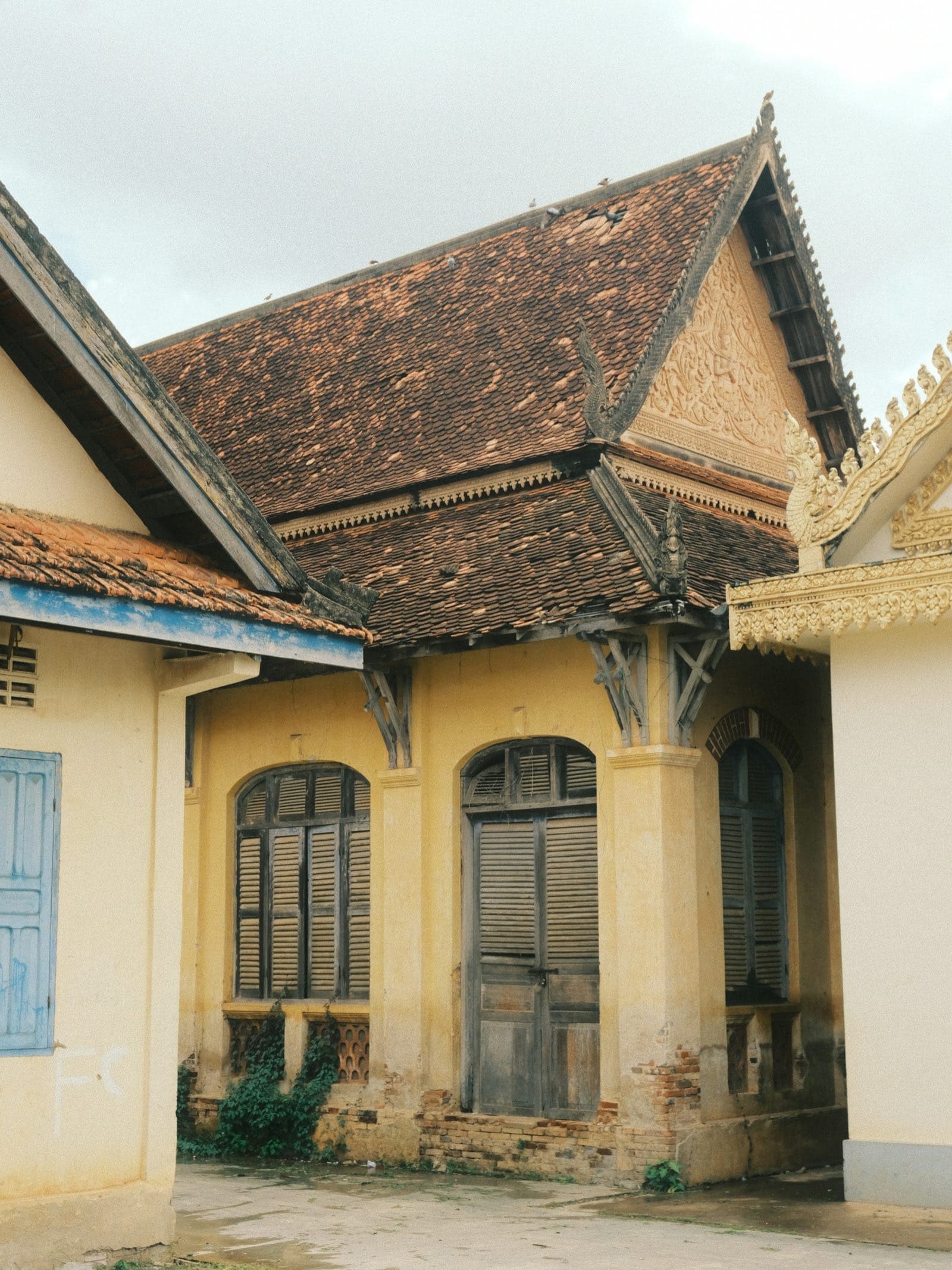 A weathered ochre colonial villa in Battambang