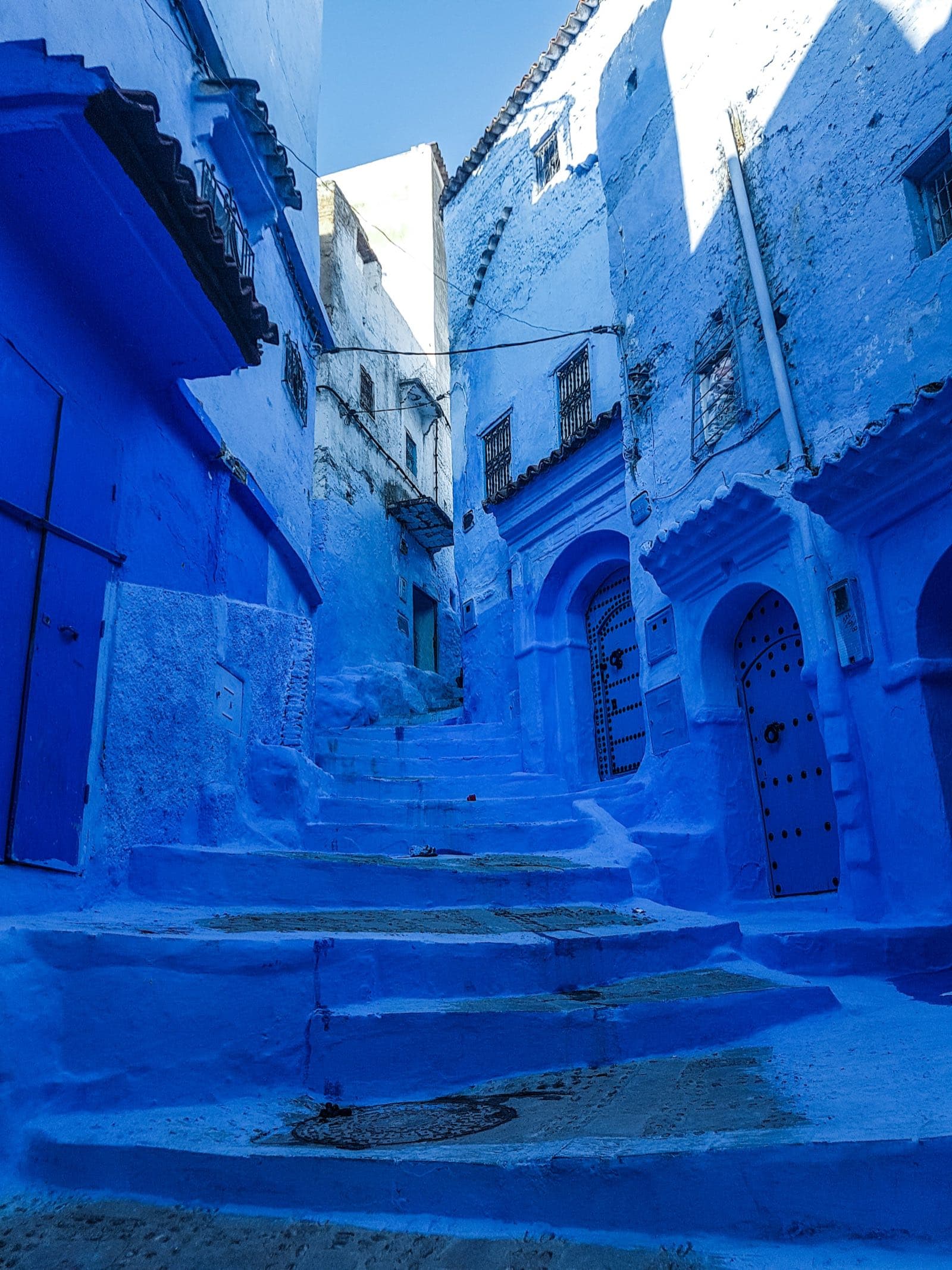 An empty cobalt-blue stairway in the Chefchaouen medina