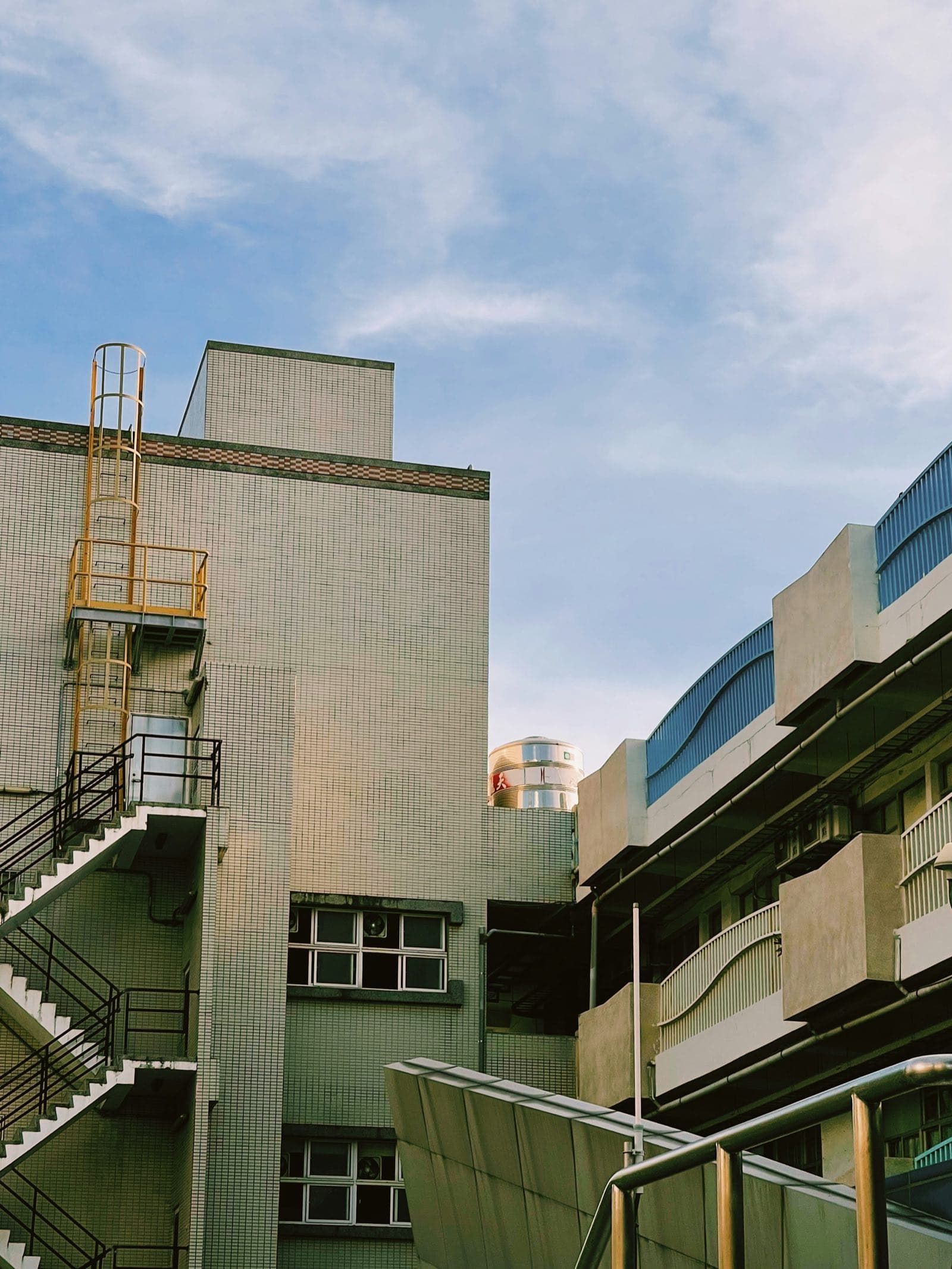 Pale sage tiled buildings with zigzag fire stairs in Kaohsiung