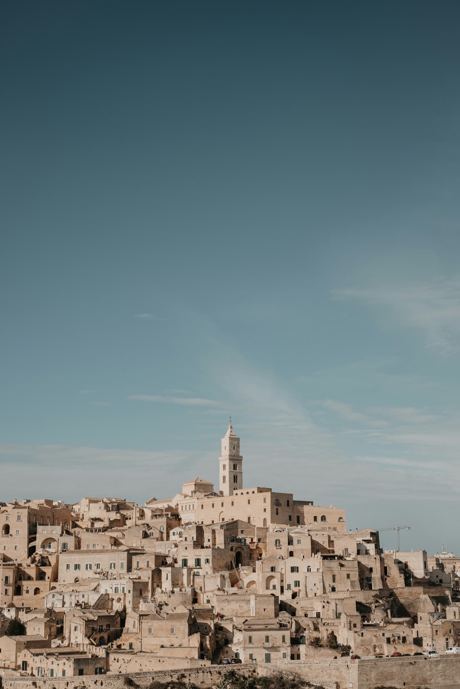 The Sassi of Matera beneath a wide teal sky